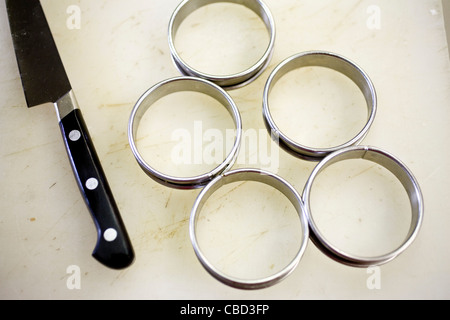 Kitchen knife and stainless steel circular rings used for dressing plates Stock Photo