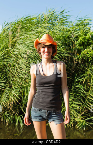Woman in cowboy hat smiling outdoors