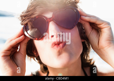Woman in sunglasses posing on beach Stock Photo