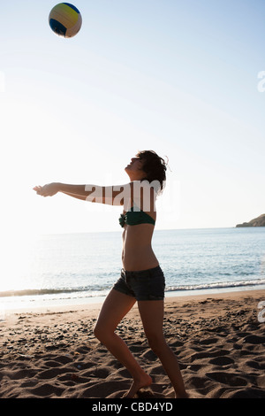 Woman playing with volleyball on beach Stock Photo