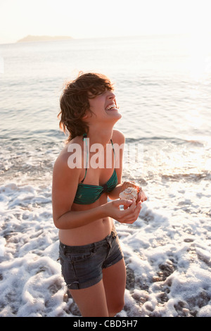 Woman holding seashells on beach Stock Photo