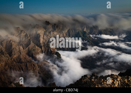 Fog rolling over rocky mountains Stock Photo
