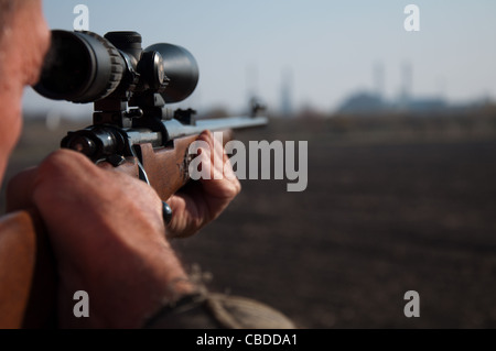 Hunter aiming with sniper rifle Stock Photo