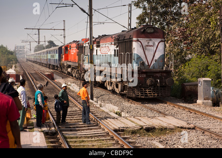 India, West Bengal, Kolkata, Dakshineswar Railway Station, passengers waiting for train pulled by two locomotives to pass Stock Photo