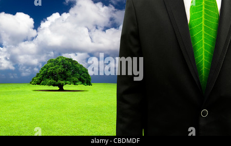 green business concept.Businessman with leaf tie and old tree background Stock Photo