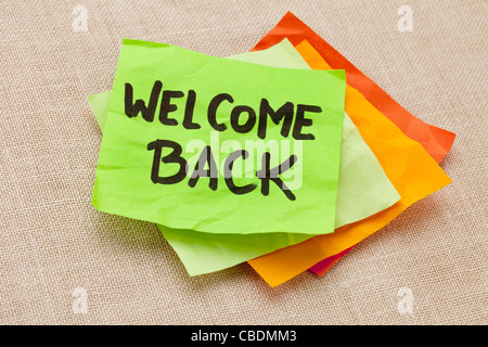 welcome back - handwriting on a green sticky note against canvas board Stock Photo