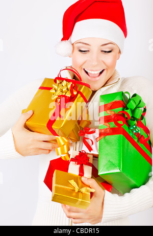 Happy Santa girl holding colorful Christmas gifts and presents, Christmastime fun and joy, celebration of winter holidays Stock Photo