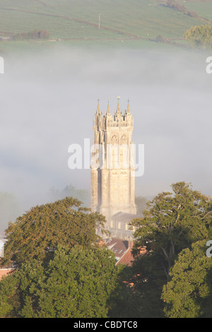 The steeple of St John the Baptist church surrounded by mist as viewed from the top of Glastonbury Tor Stock Photo