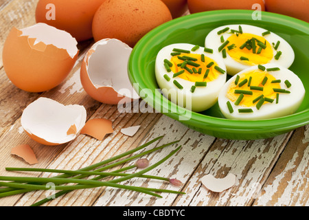 boiled chicken eggs with green chive against grunge wood surface - Easter or spring concept Stock Photo