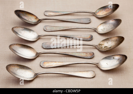 old grunge silver spoons with scratches and patina on tablecloth, shallow depth of field Stock Photo