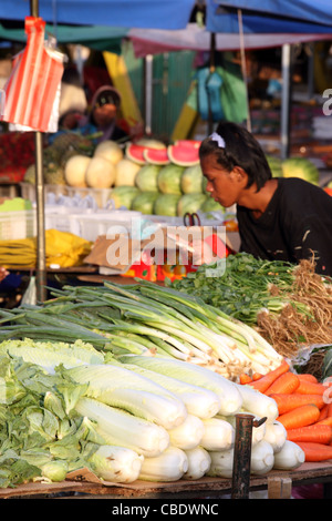 Man sending text message on cellphone at Kota Kinabalu waterfront market. Stock Photo