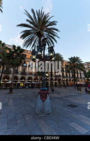 street lamp  designed by anton gaudì The palm trees and traditionally designed buildings of Placa Reial, in Barcelona, Spain Stock Photo