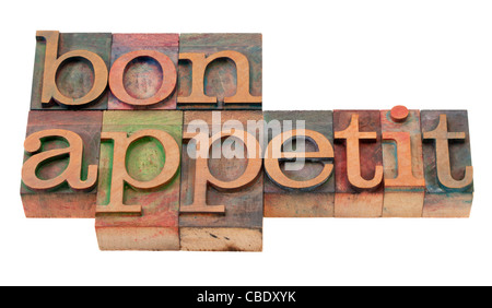 bon appetit - phrase in vintage wooden letterpress printing blocks, stained by color inks, isolated on white Stock Photo