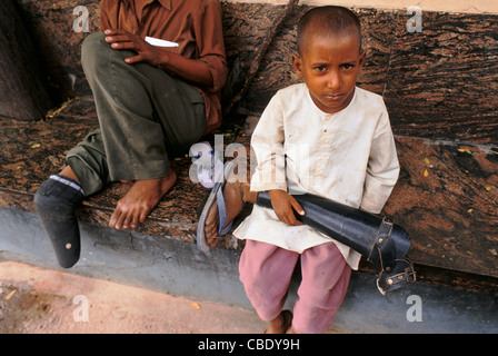 A boy is holding the leg prosthesis of a relative. The prosthesis is an Indian innovation called "Jaipur foot" ( India) Stock Photo