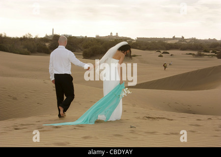 Bride and groom walking in the dunes of Maspalomas Stock Photo