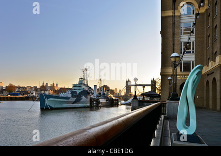 HMS Belfast and Tower Bridge on the Thames River at sunrise Stock Photo