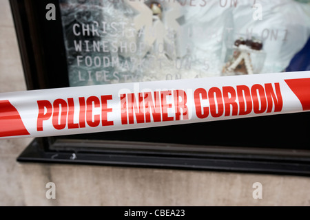 Police inner cordon tape barrier and a scene of crime officer ...