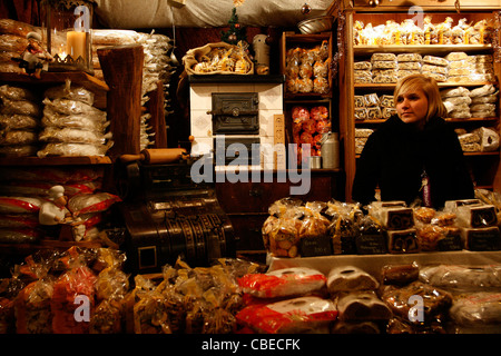 A girl is selling the traditional Christmas bread, called Stollen, in a stall at the Christmas Market in Leipzig, Germany. Stock Photo