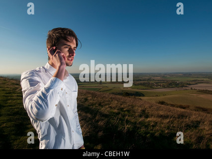 United Kingdom. Dunstable. Business man talks on the phone whilst overlooking rural setting. 2011 Stock Photo
