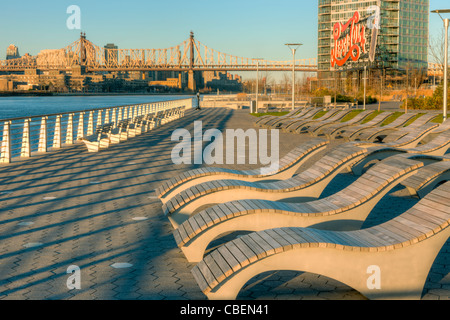 Seating with views of Manhatan and the historic Pepsi-Cola sign in Gantry Plaza State Park in Long Island City, Queens, New York. Stock Photo