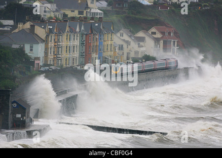 Waves crash onto a train as it heads into Dawlish station during atrocious weather conditions. Picture by James Boardman Stock Photo