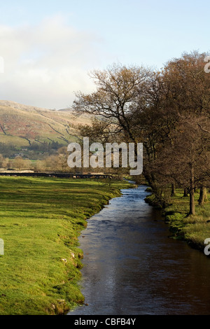 Austwick Beck with  Studrigg Scar and Long Scar in the background winter Austwick Yorkshire Dales National Park England Stock Photo