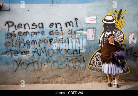 Bolivian woman standing in front of a wall mural in Potosi' Bolivia Stock Photo