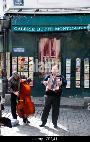 Two men playing instruments on Paris street in Montmartre Stock Photo