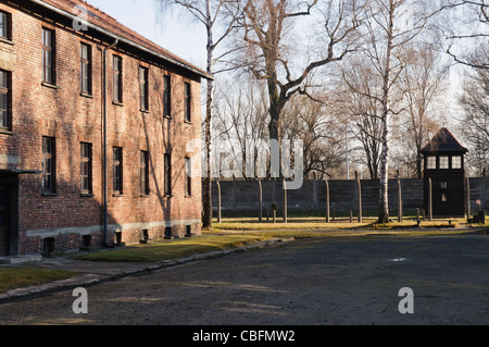 Barracks at Auschwitz I Nazi concentration camp with electric fence and Watchtower Stock Photo
