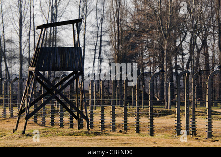 Watchtower beside electrified barbed wire security fence at Auschwitz Berkenau Nazi concentration camp Stock Photo