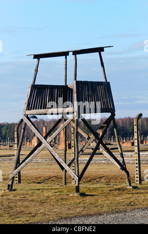 Watchtower beside electrified barbed wire security fence at Auschwitz Berkenau Nazi concentration camp Stock Photo