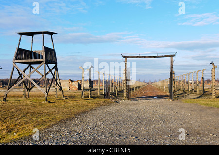 Watchtower beside electrified barbed wire security fence at Auschwitz Berkenau Nazi concentration camp Stock Photo