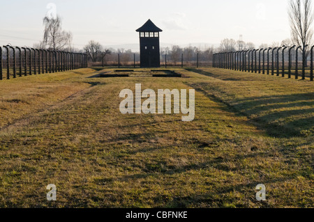 Watchtower beside electrified barbed wire security fence at Auschwitz Berkenau Nazi concentration camp Stock Photo