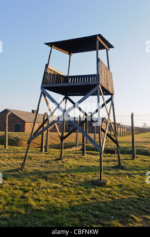 Watchtower beside electrified barbed wire security fence at Auschwitz Berkenau Nazi concentration camp Stock Photo