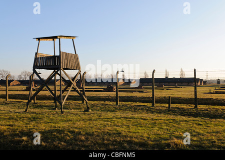 Watchtower beside electrified barbed wire security fence at Auschwitz Berkenau Nazi concentration camp Stock Photo