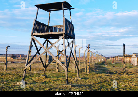 Watchtower beside electrified barbed wire security fence at Auschwitz Berkenau Nazi concentration camp Stock Photo