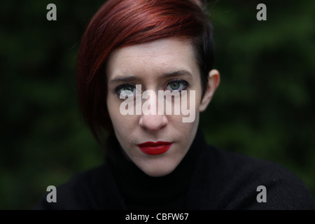 Young attractive woman with red hair looking straight into the camera Stock Photo
