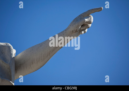 Statue pointing, blue sky background, close-up of arm Stock Photo