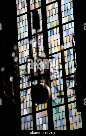 A stained glass window in back of a chandelier, focus on window Stock Photo