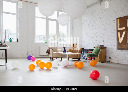 Multi colored balloons on the floor of a modern living room Stock Photo