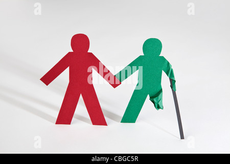 Two paper dolls holding hands, one with an injury Stock Photo