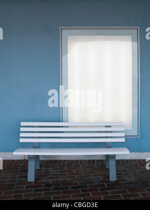 Empty bench on tiled floor in front of window Stock Photo