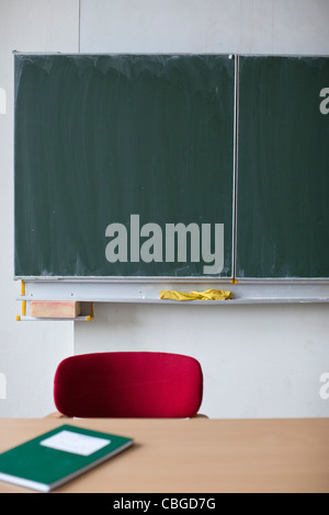 Blackboard behind teachers desk Stock Photo