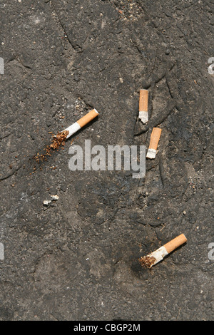 four cigarette stubs on floor ground Stock Photo