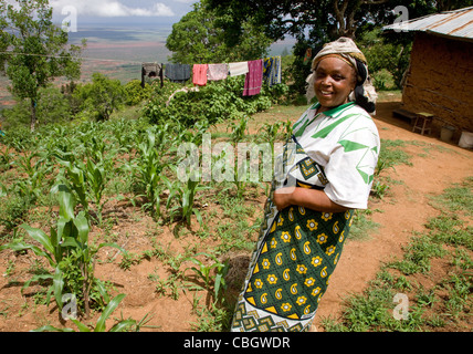 Smiling Kenyan woman outside her house in the Sagalla Hills of southern Kenya and her washing line overlooking the Ndara Plain Stock Photo