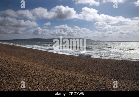 Clouds gather over a shingle beach on a sunny winters day. Solent and Isle of Wight. Hampshire, England. Stock Photo