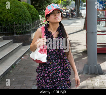 Young Chinese woman thinking at street in city of Shanghai, purple, hat fashion Stock Photo