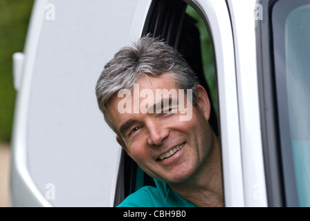MAN HAPPY WHITE VAN SELF-EMPLOYED TRADE Smiling confident mature 40-50 years man in white tradesman’s van. British Brexit business confidence concept Stock Photo