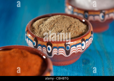 Red pepper, salt and savory in traditional bulgarian ceramic bowls on blue background Stock Photo