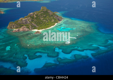 Monuriki Island and coral reef, Mamanuca Islands, Fiji, South Pacific - aerial Stock Photo